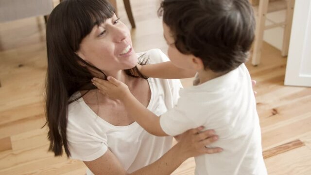Joyful mom hugging, cuddling and kissing sweet little boy. Mother enjoying time with son. Family and parenthood concept