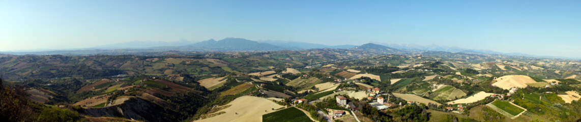 Fototapeta na wymiar Italian rural landscape Marche countryside with plowed fields ready for sowing, clear sky without clouds, Mediterranean vegetation, Apennine mountains in the background. Seismic area near Amatrice
