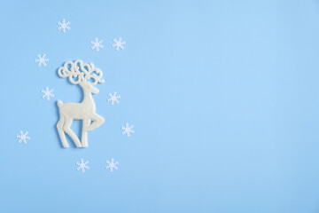 Christmas reindeer and snowflakes on blue background. Flat lay, top view. Winter holidays greeting...