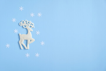 Christmas reindeer and snowflakes on blue background. Flat lay, top view. Winter holidays greeting card mockup.