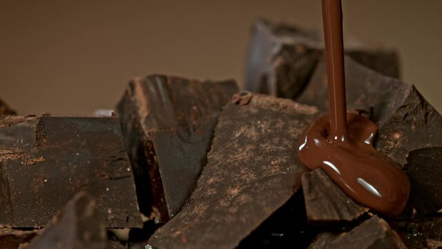 Super Slow Motion Shot of Pouring Melted Chocolate on Raw Chocolate Chunks at 1000 fps.