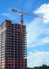 Construction of a modern frame residential building. Tower construction crane.