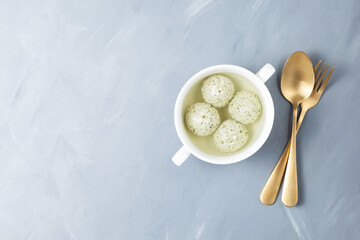 Turkey meatballs with spinach in bone broth on a gray background with copy space. A dietary product with natural collagen