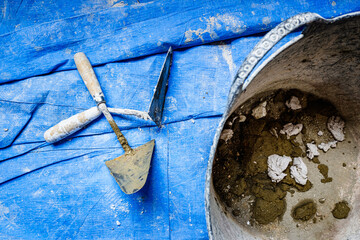 Rubble from a bricklaying work on a blue protective cloth, nobody.