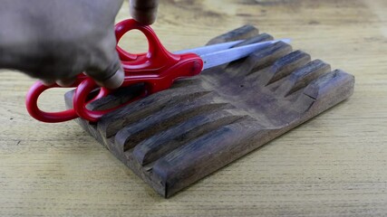 Scissors with red handle Put in the scissors container.