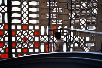 A man putting glass to the wall