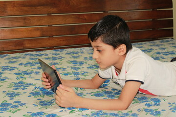 Kid watching movie on Tablet pc. Kid playing on tablet pc. Kid at home during lock down