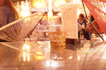 glass table and Menu in french in a public place surrounded with indistinct lights and people
