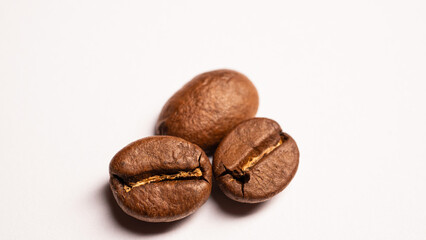 three coffee beans on a white table