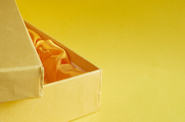Edge of a yellow cardboard box on yellow background