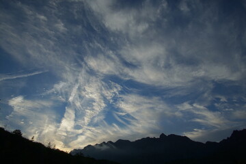 View of the dramatic sky above the city at sunset with dark white clouds