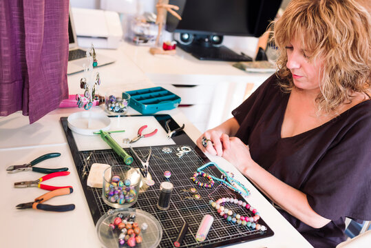 young woman in jewelry size making jewelry with polymer clay. - Powered by Adobe