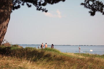 Fototapeta na wymiar Holiday season by the lake, where people enjoy the summer weather on a warm sunny day