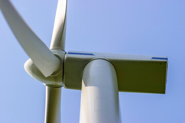 Close up at a wind turbine against a blue sky