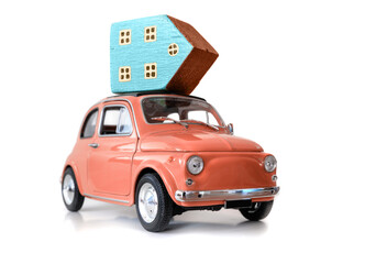 Toy retro car with house model on the roof on the white background