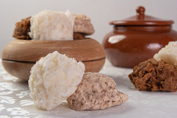 Brazilian cocada (coconut candy) placed in a wooden pot on a table with white towel, selective focus.