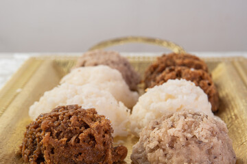 Brazilian cocada (coconut candy) placed on a golden tray on a table with white towel, selective focus.