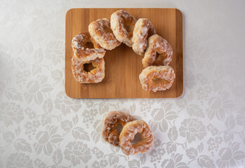 sugar-coated sweet cookies placed on a polished board on a table with white tablecloth, Top view.