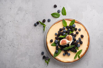 Homemade cheesecake with fresh berries and mint for dessert - healthy organic summer dessert pie cheesecake. Cheese cake. Grey background. Copy space.