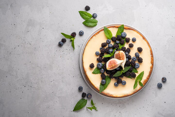 Homemade cheesecake with fresh berries and mint for dessert - healthy organic summer dessert pie cheesecake. Cheese cake. Grey background. Copy space.