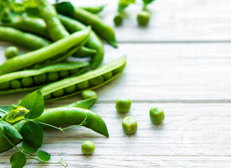 Green peas  on a white wooden background.  Healthy food background.