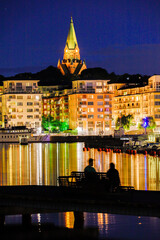 Stockholm, Sweden A couple watch the skyline of Sodermalm island at night and the Sofia church.