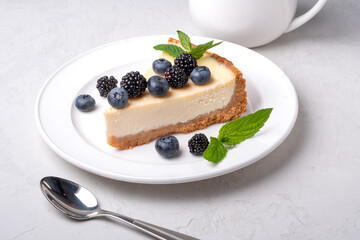 Cheesecake slice, New York style classical cheese cake on grey background. Slice of tasty cake on white plate