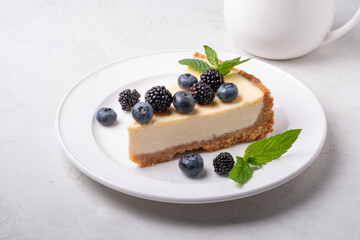 Cheesecake slice, New York style classical cheese cake on grey background. Slice of tasty cake on white plate