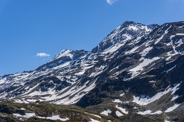 The snow-capped mountains of the Spluga valley during early summer, near the town of Madesimo, Italy - June 2020.
