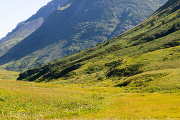 Panoramic mountain view, beautiful landscape on a Sunny day with green grass in the meadows