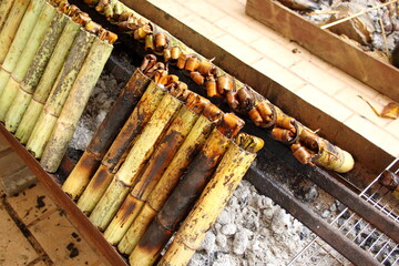 Sticky rice roasted in bamboo join or Khao Lam row roasting on stove. In Thailand Khao Lam is favorite thai dessert and must cracked the bamboo before eat.