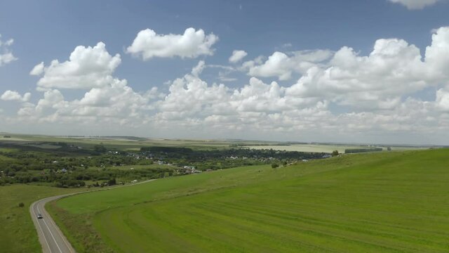 Scenic aerial panoramic view of idyllic rolling hills spring landscape in with lush green mountain pastures in evening light at sunset