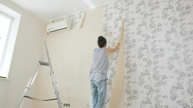 The process of removing old Wallpaper from the walls in the room during repairs in the apartment.