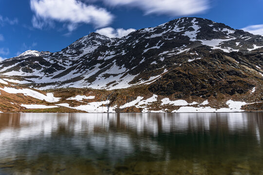 A lake during the summer in the Italian Alps, near the town of Madesimo, Italy - June 2020.