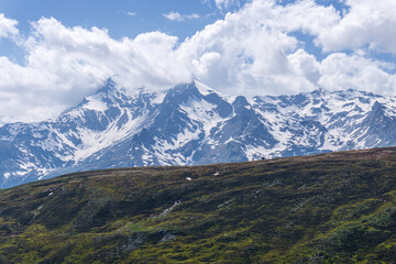Obraz premium The snow-capped mountains of the Spluga valley during early summer, near the town of Madesimo, Italy - June 2020.