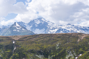 Obraz premium The snow-capped mountains of the Spluga valley during early summer, near the town of Madesimo, Italy - June 2020.