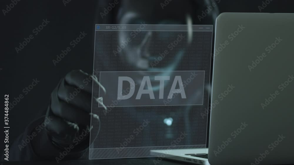 Poster hacker wearing black mask pulls data tab from a laptop