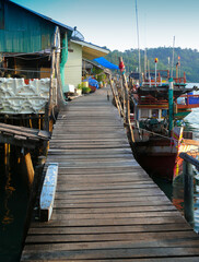 Fototapeta na wymiar The fishing village houses a wooden bridge and a fishing boat.