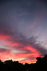 Colorful clouds and city silhouette at sunset