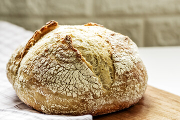 Fresh baked loaf of bread. Rustic sourdough bread on a napkin. Close up. Selective focus