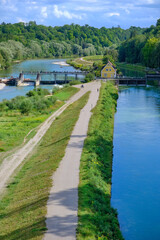 A dam on the river. A house surrouned by river. View from the bridge