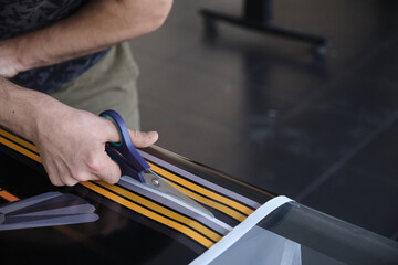 Man cutting print paper with scissors