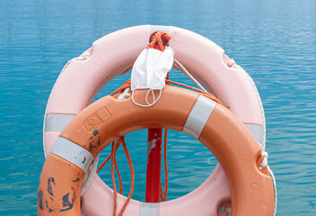 Two Lifesavers - zwei Corona Masken bzw. Mund-Nasen-Schnutz hängen am Hafen an roten Rettungsringen