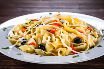 Pasta with parmesan and vegetables on wooden table
