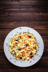 Pasta with parmesan and vegetables on wooden table
