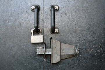 Part of an iron door with a modern locking device.