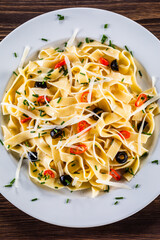 Pasta with parmesan and vegetables on wooden table
