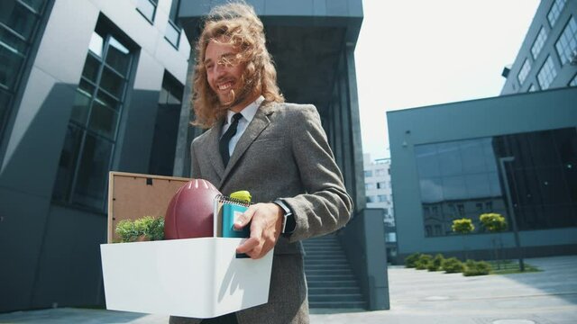 Cheerful young office manager executive celebrate job dismissal leaving the boring grey office department fell very happy. Fired businessman. Happiness and freedom.