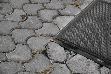 Rectangular black manhole cover and paving stones details