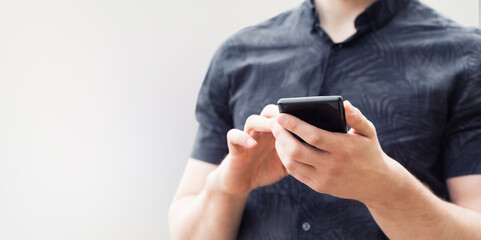 Image of a man`s hands using a smart phone, close up.
